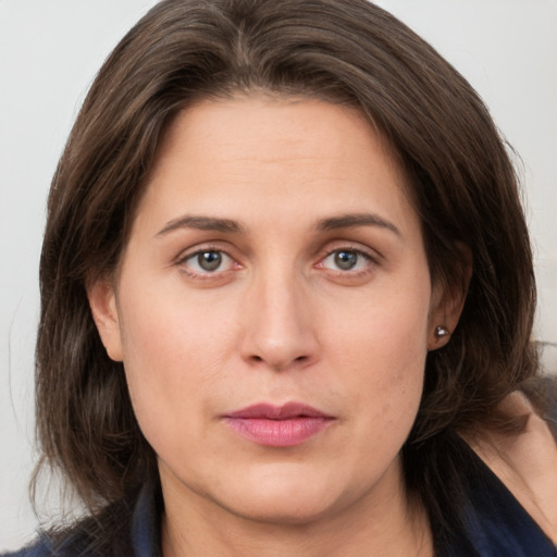 Joyful white adult female with medium  brown hair and grey eyes