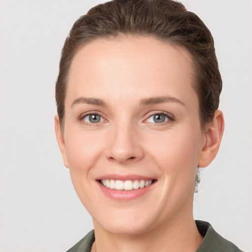 Joyful white young-adult female with short  brown hair and grey eyes