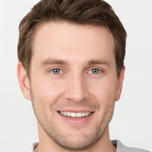 Joyful white young-adult male with short  brown hair and grey eyes