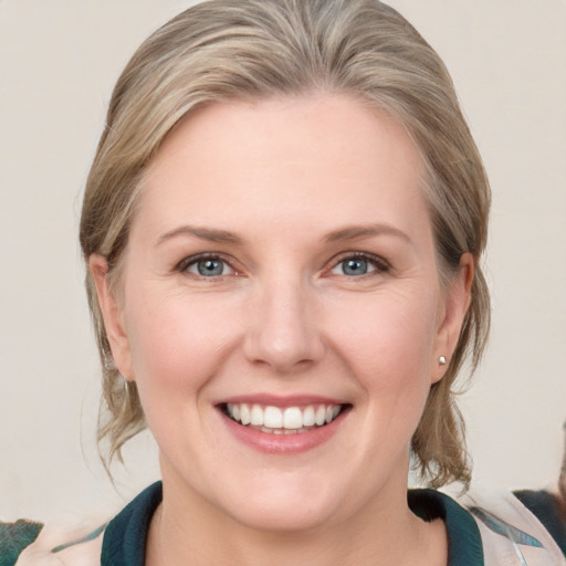 Joyful white young-adult female with medium  brown hair and blue eyes