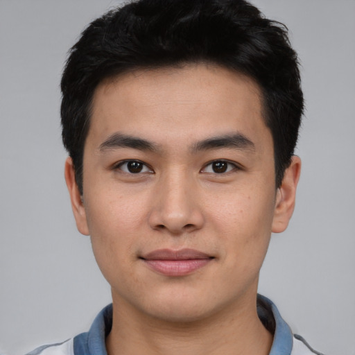 Joyful asian young-adult male with short  black hair and brown eyes