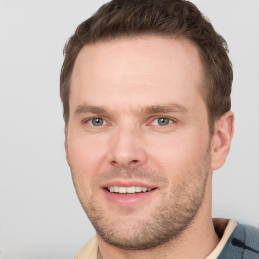 Joyful white young-adult male with short  brown hair and grey eyes