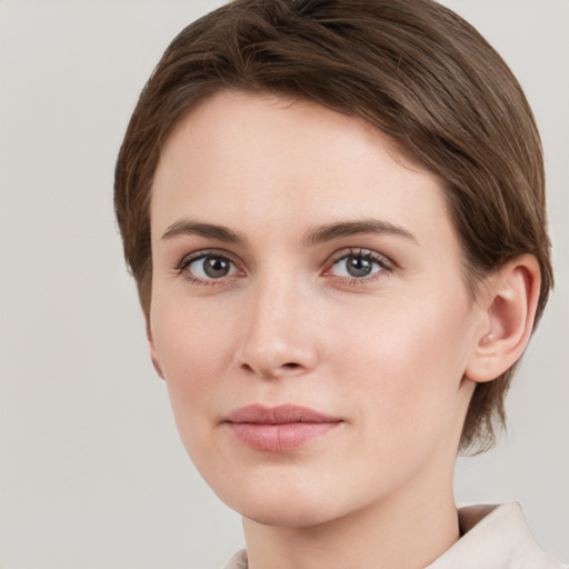 Joyful white young-adult female with short  brown hair and grey eyes