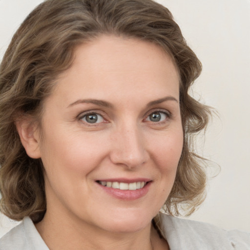 Joyful white young-adult female with medium  brown hair and blue eyes