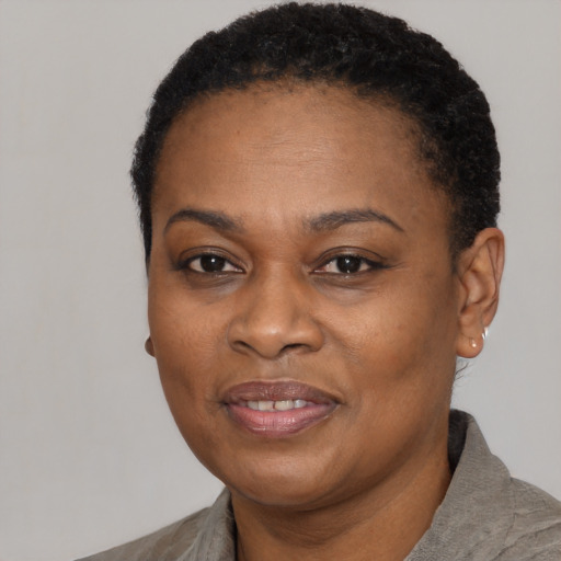 Joyful black adult female with short  black hair and brown eyes