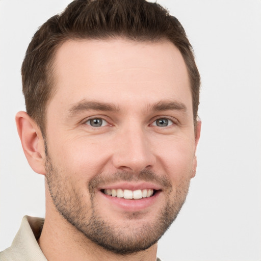 Joyful white young-adult male with short  brown hair and grey eyes