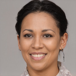 Joyful latino adult female with medium  brown hair and brown eyes