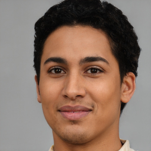 Joyful latino young-adult male with short  black hair and brown eyes