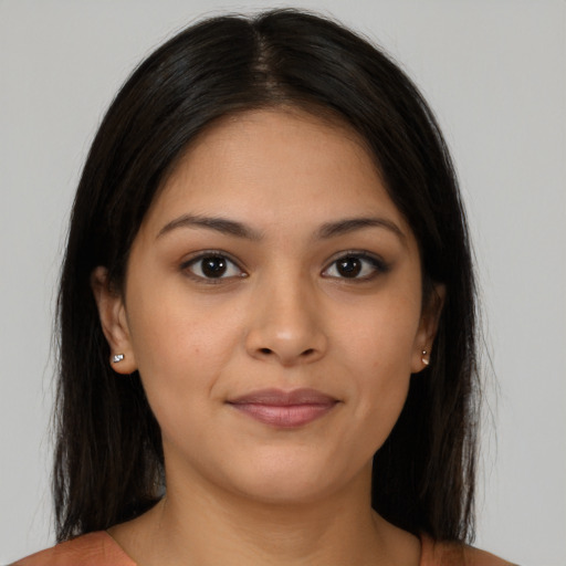 Joyful latino young-adult female with long  brown hair and brown eyes