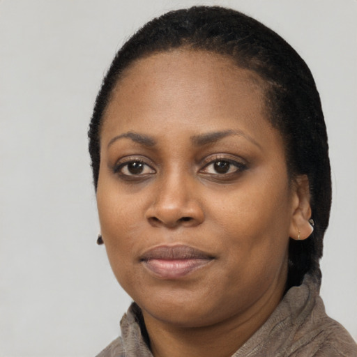 Joyful black young-adult female with short  black hair and brown eyes