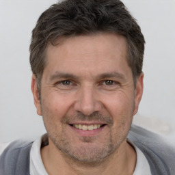 Joyful white adult male with short  brown hair and brown eyes