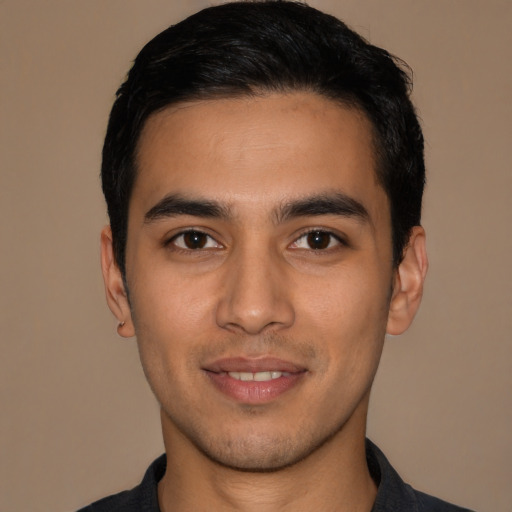 Joyful latino young-adult male with short  black hair and brown eyes
