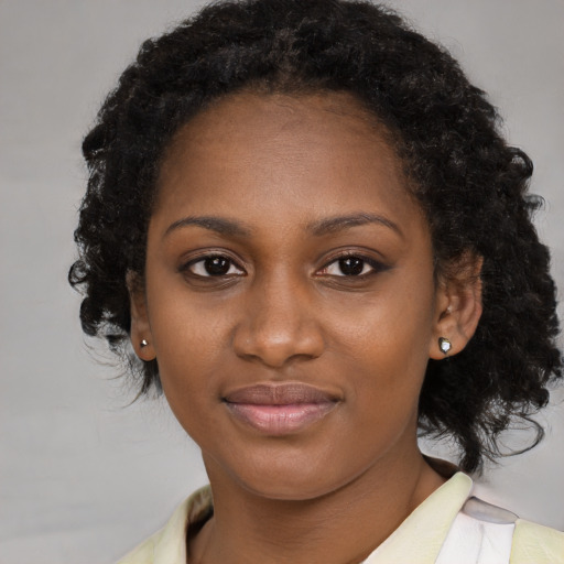 Joyful black young-adult female with long  brown hair and brown eyes
