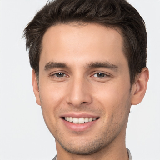 Joyful white young-adult male with short  brown hair and brown eyes