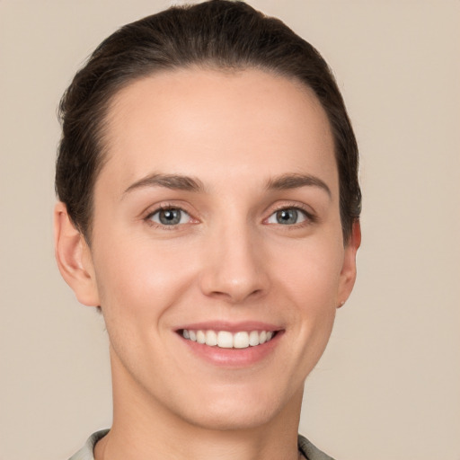 Joyful white young-adult female with short  brown hair and grey eyes