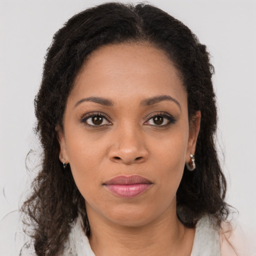 Joyful black young-adult female with long  brown hair and brown eyes