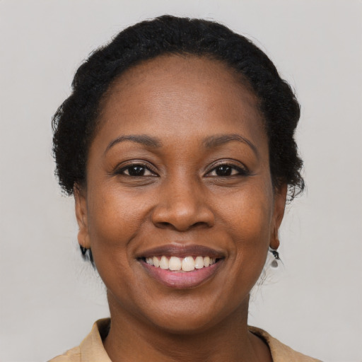 Joyful black adult female with short  black hair and brown eyes