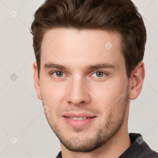 Joyful white young-adult male with short  brown hair and grey eyes