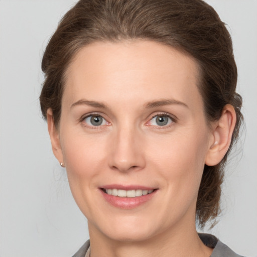 Joyful white young-adult female with medium  brown hair and grey eyes