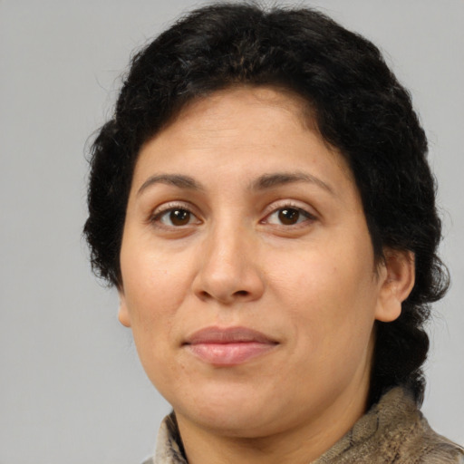 Joyful latino adult female with medium  brown hair and brown eyes