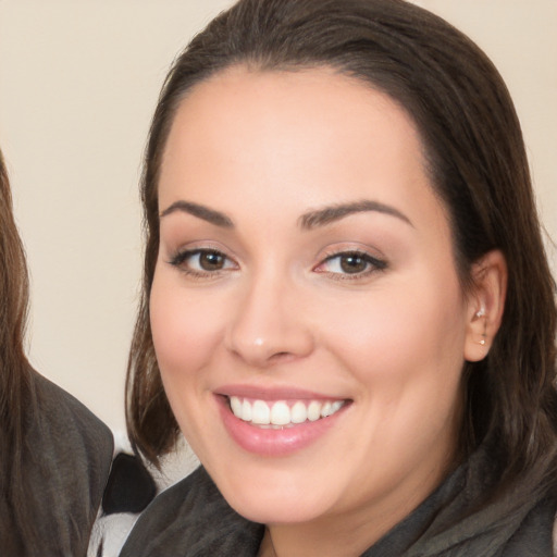 Joyful white young-adult female with long  brown hair and brown eyes