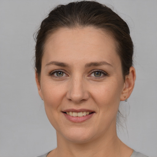 Joyful white young-adult female with short  brown hair and grey eyes