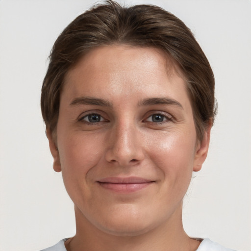 Joyful white young-adult female with short  brown hair and grey eyes