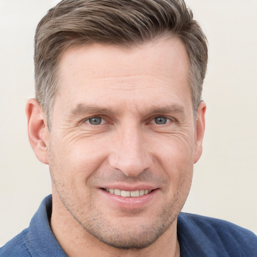 Joyful white adult male with short  brown hair and grey eyes