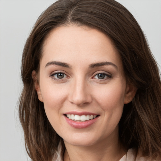 Joyful white young-adult female with long  brown hair and grey eyes