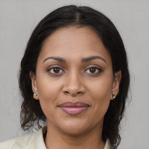 Joyful black young-adult female with medium  brown hair and brown eyes