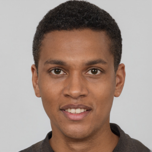 Joyful black young-adult male with short  brown hair and brown eyes