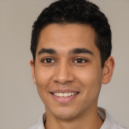 Joyful latino young-adult male with short  black hair and brown eyes