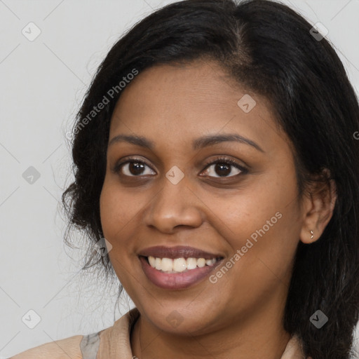 Joyful black young-adult female with long  brown hair and brown eyes