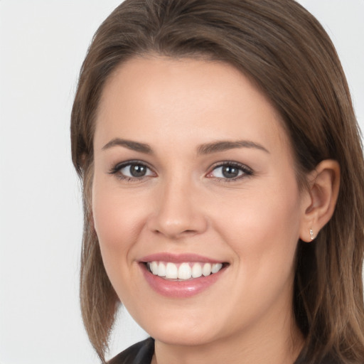 Joyful white young-adult female with long  brown hair and brown eyes