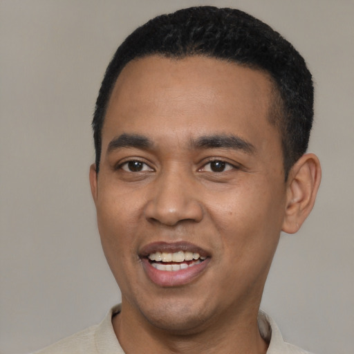 Joyful black young-adult male with short  black hair and brown eyes