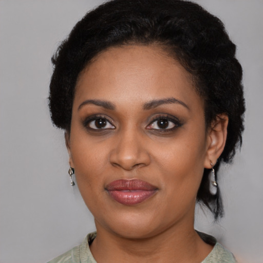 Joyful black young-adult female with short  black hair and brown eyes