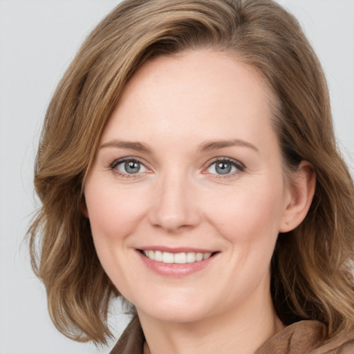 Joyful white young-adult female with medium  brown hair and blue eyes