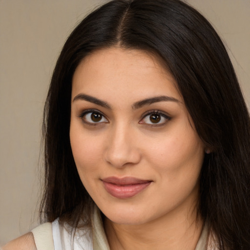 Joyful latino young-adult female with long  brown hair and brown eyes