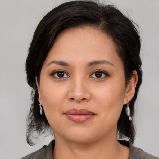 Joyful latino young-adult female with medium  brown hair and brown eyes