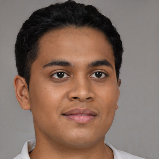 Joyful latino young-adult male with short  brown hair and brown eyes