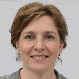 Joyful white adult female with medium  brown hair and grey eyes