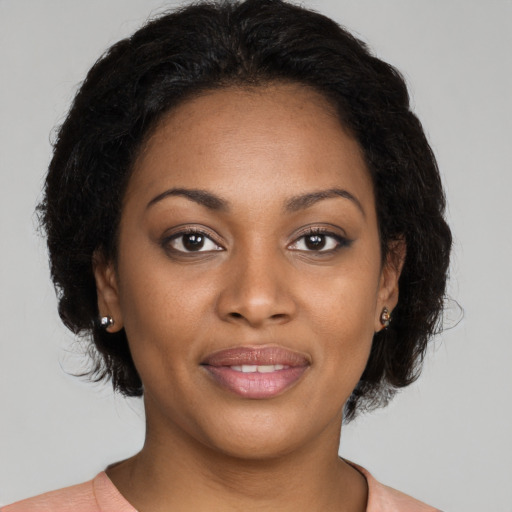 Joyful black young-adult female with medium  brown hair and brown eyes