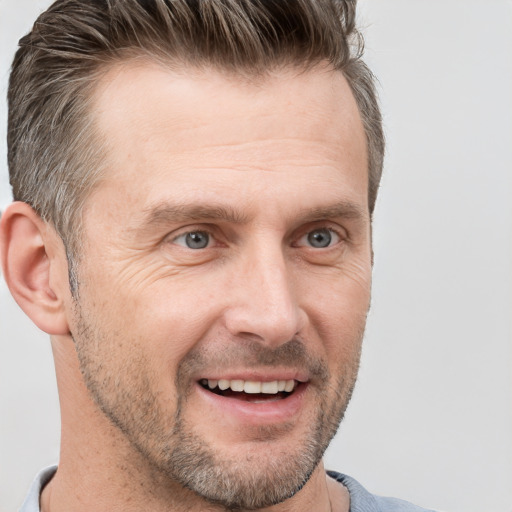 Joyful white adult male with short  brown hair and grey eyes