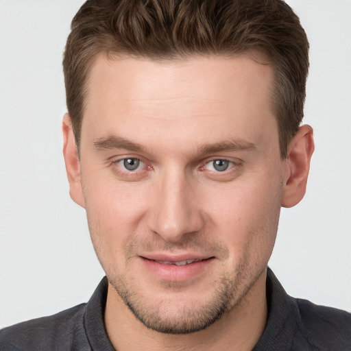 Joyful white young-adult male with short  brown hair and grey eyes