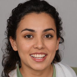 Joyful latino young-adult female with medium  brown hair and brown eyes