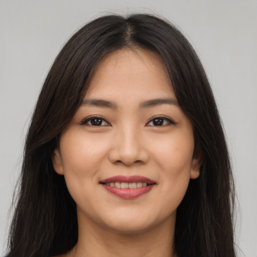 Joyful asian young-adult female with long  brown hair and brown eyes