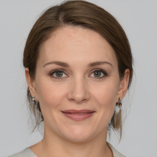 Joyful white young-adult female with medium  brown hair and green eyes