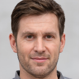 Joyful white adult male with short  brown hair and brown eyes