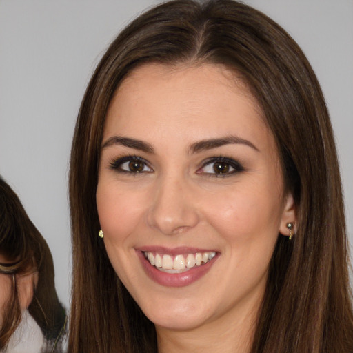 Joyful white young-adult female with long  brown hair and brown eyes