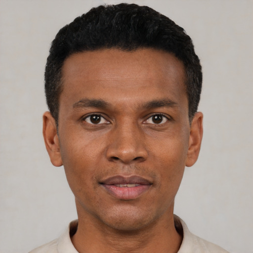 Joyful black young-adult male with short  black hair and brown eyes